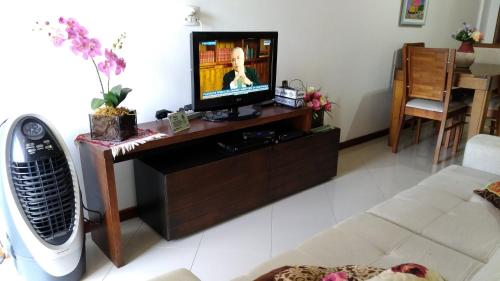 sala de estar con TV sobre una mesa de madera en Praia de Itapuã, en Río de Janeiro