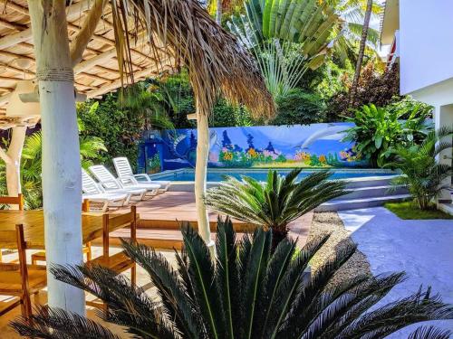 un complejo con una piscina con sillas y palmeras en Casa Brisa Mar Hotel, en Las Terrenas
