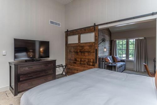 a bedroom with a bed and a flat screen tv at Ghost Light Inn in New Hope