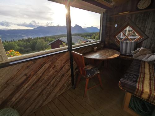 Habitación con mesa y ventana en una cabaña en Eikre Fjellgård, en Hemsedal