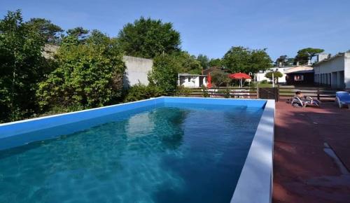 una gran piscina de agua azul en un patio en Alfil Apartamentos Villa Gesell en Villa Gesell