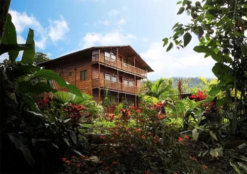 a house in the middle of a garden with flowers at Mindo Green House in Mindo