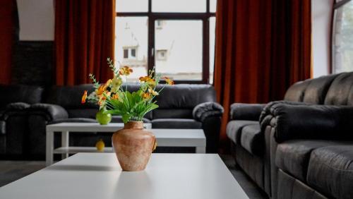 a vase with flowers on a table in a living room at Hotel Cirus in Predeal
