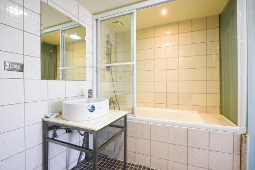 新竹市的住宿－豪美商旅，浴室配有盥洗盆和浴缸。