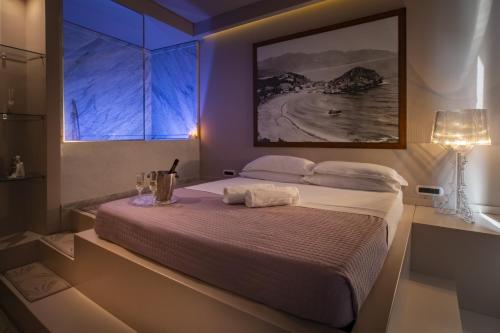 a bedroom with a large bed and a window at Fenetre sur le blue in Taormina