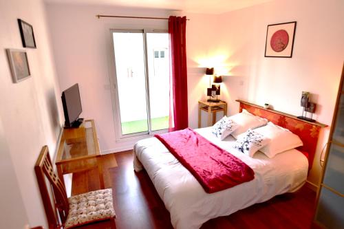a bedroom with a bed with a large window at Appartement luxueux 100m² Bordeaux in Le Bouscat