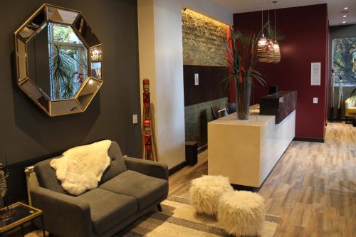 sala de estar con sofá y espejo en MG Design Hotel Boutique en Salta