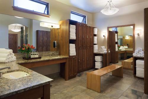 a bathroom with a sink and a large mirror at Stonebridge Inn in Snowmass Village