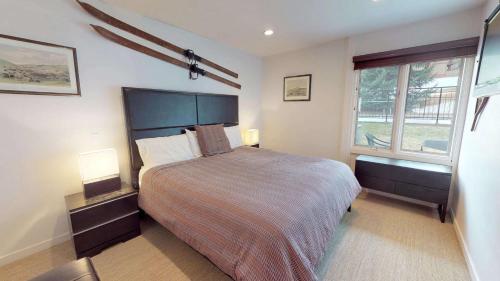 a bedroom with a large bed and two windows at Lichenhearth - CoralTree Residence Collection in Snowmass Village