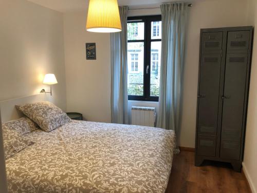 une chambre avec un lit et une fenêtre dans l'établissement AU VIEUX LAVOIR avec Parking privé, Jardin , Climatisation, à 500 m de la cité, à Carcassonne