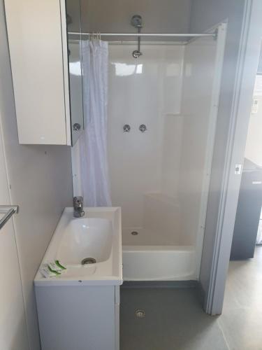 a white bathroom with a sink and a shower at Terminus Hotel in Coonamble