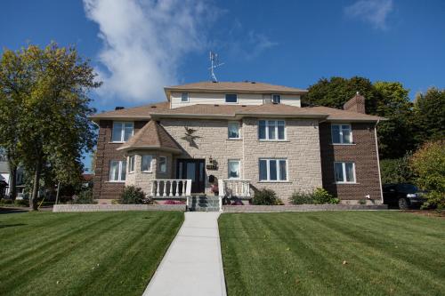 una mujer parada frente a una gran casa de ladrillo en Butterfly Manor, en Niagara Falls