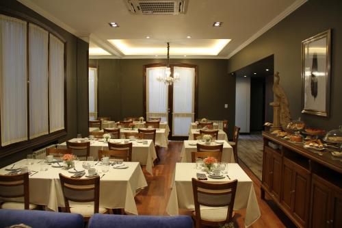 un comedor con mesas y sillas blancas en MG Design Hotel Boutique en Salta