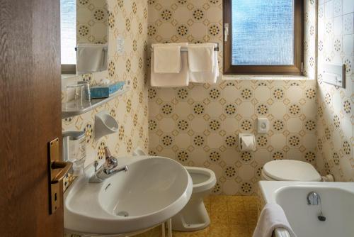 a bathroom with a sink and a toilet at Pension Gasthof Löwen in Lagundo