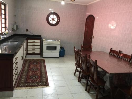 a kitchen with a table and a stove top oven at Chácara Paraíso de Itamonte MG in Itamonte