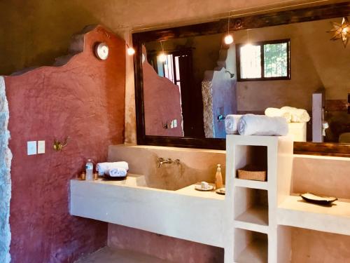 a bathroom with a sink and a large mirror at Hacienda Sacnicte in Izamal