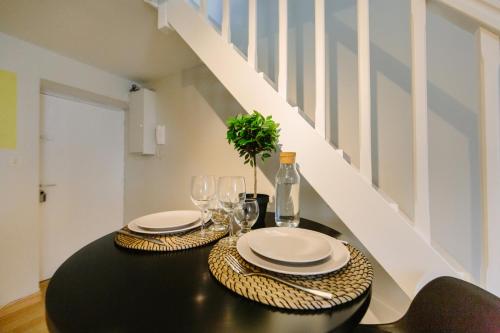 - une table à manger avec des assiettes et des verres à vin dans l'établissement Le Trendy - Duplex pétillant : Place Graslin / Dobrée, à Nantes