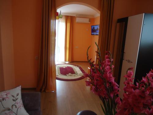 a living room with orange walls and a vase of flowers at Marani Hotel in Batumi