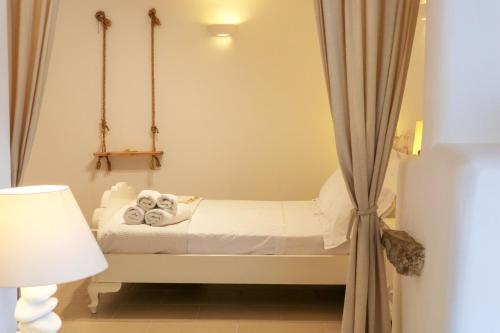 a small room with a bed with a curtain at Ortus Ivory Mykonian Lux Villa With POOL! in Mýkonos City