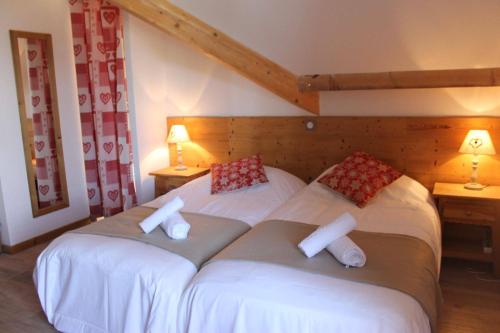 deux lits jumeaux dans une chambre avec deux lampes dans l'établissement Chalet Grande Etoile des Neiges, à L'Alpe-d'Huez