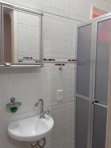 a bathroom with a sink and a mirror and a shower at Menina da Lua in Rio das Ostras