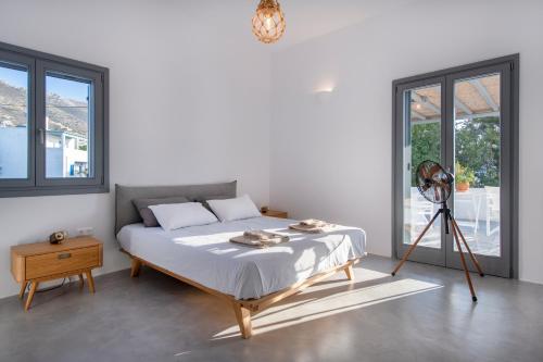 a white bedroom with a bed and a tripod at Parikia's Crossroad 3 Bedroom House in Kampos Paros