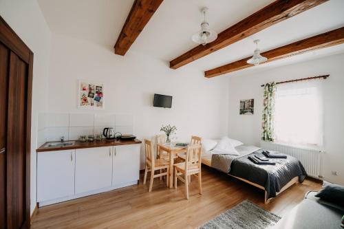 Zimmer mit einem Bett, einer Küche und einem Tisch in der Unterkunft Piękne Roztocze in Zamość
