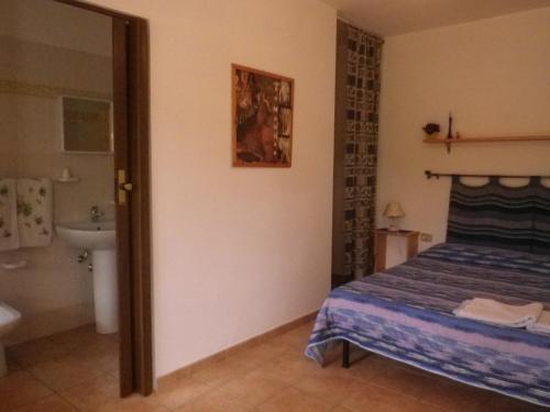 1 dormitorio con 1 cama y baño con lavamanos en Centro di Turismo Equestre SHANGRILA', en Fluminimaggiore