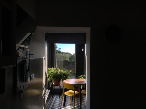 a room with a table and chairs and a window at Villa Várzea Design Nest in Várzea