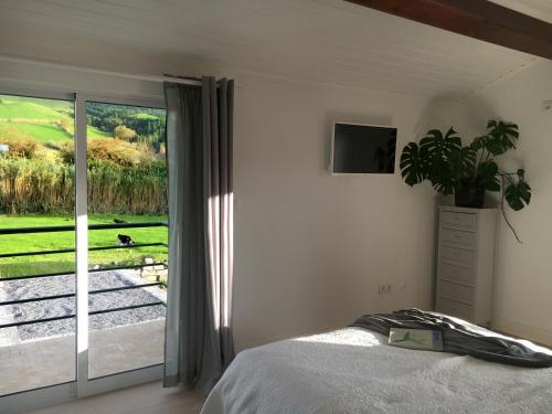 a bedroom with a bed and a sliding glass door at Villa Várzea Design Nest in Várzea