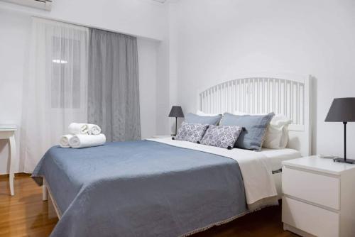 ein weißes Schlafzimmer mit einem großen Bett und einem Fenster in der Unterkunft Apartment one breath from Acropolis in Athen