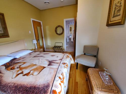 a bedroom with a bed, desk and a lamp at Gite Au P'tit Manoir B&B in Saguenay