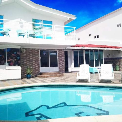 a house with a swimming pool in front of a house at Hotel Mare Mare Inn in San Andrés