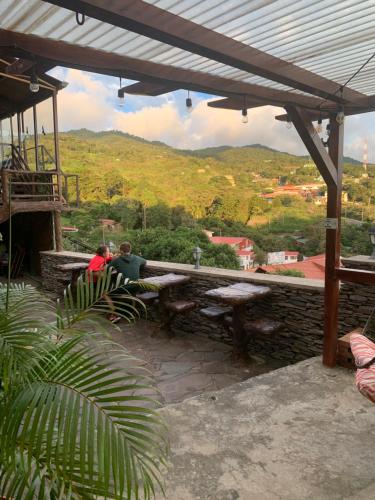 two people sitting on a bench under a stone wall at Cabinas Vista Al Golfo in Monteverde Costa Rica