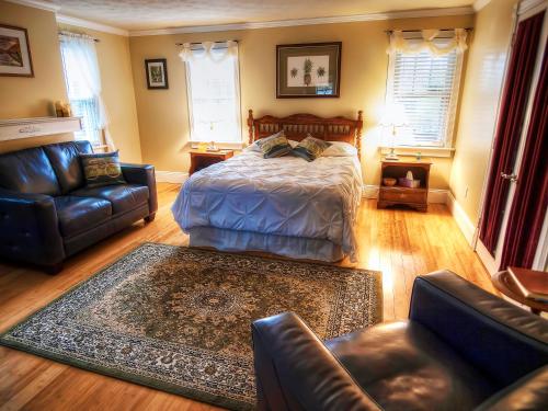 a living room with a bed and a couch at Foster's Bethel Beach Inn in Onemo