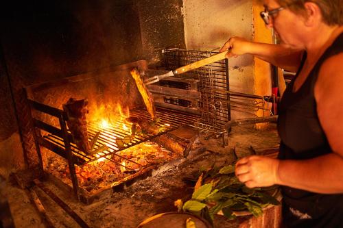 a woman is cooking food in an oven at Agriturismo Casa VolaterrA in Volterra