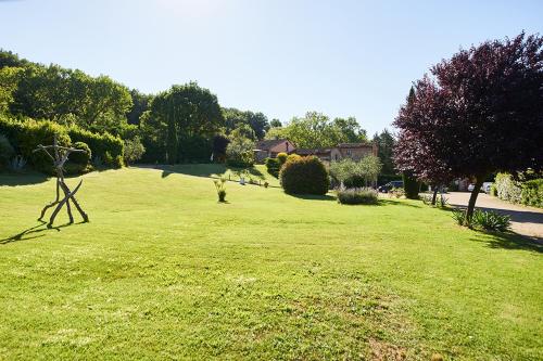 a large field of green grass with a house in the background at Agriturismo Casa VolaterrA in Volterra