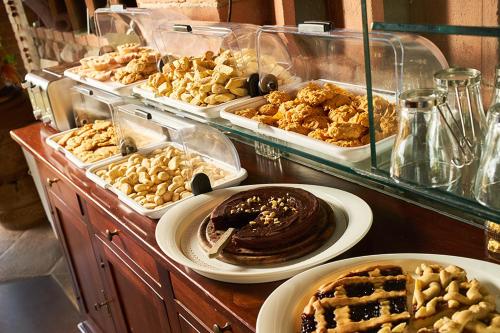 a buffet filled with different types of pastries and desserts at Agriturismo Casa VolaterrA in Volterra
