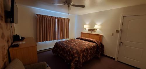a hotel room with a bed and a window at Bridge Street Inn in Baker City
