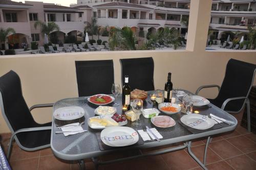 a table with food and bottles of wine on it at 2 Bed, 2 Bath Apartment In Mandria in Mandria
