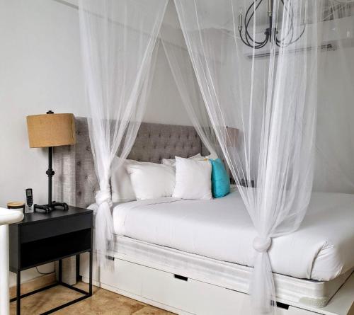 een slaapkamer met een wit bed en een baldakijn bij KASA Roof Top 5 1 Bed 1 Bath for 2 Guests AMAZING Views Old San Juan in San Juan