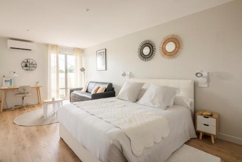 1 dormitorio blanco con 1 cama grande y 1 silla en Studio Confort O NICO-Dormiratoulouse Colomiers en Colomiers