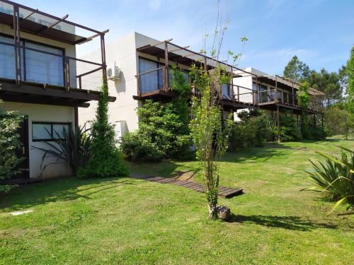 uma casa com um jardim verde em frente em La Bonita Suites Punta Colorada em Punta Colorada