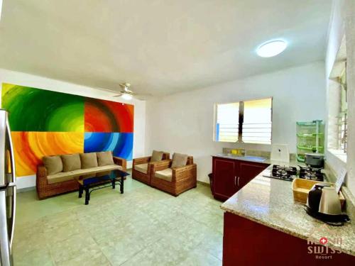 een woonkamer met een regenboog schilderij aan de muur bij Alona Swiss Resort in Panglao