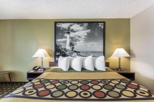 a large bed in a hotel room with two lamps at Super 8 by Wyndham Ocala I-75 in Ocala