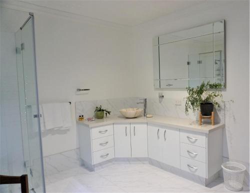 a white bathroom with a sink and a mirror at Broxholme B&B in Denmark