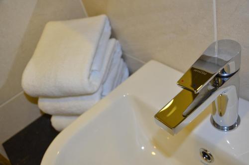 a bathroom with a sink with a gold faucet at SEM9 Senai "Formerly Known As Perth Hotel" in Kulai