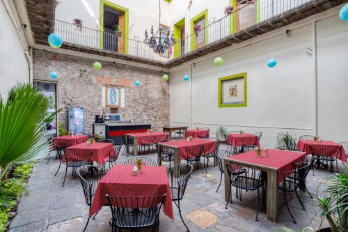 a patio with tables and chairs in a restaurant at Hostal Santo Domingo in Puebla