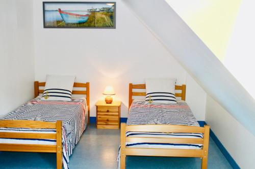 - 2 lits jumeaux dans une chambre avec escalier dans l'établissement Les Oiseaux, à Barneville-Carteret