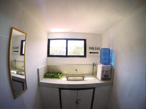 a small bathroom with a sink and a mirror at JMP Hostel in Coron